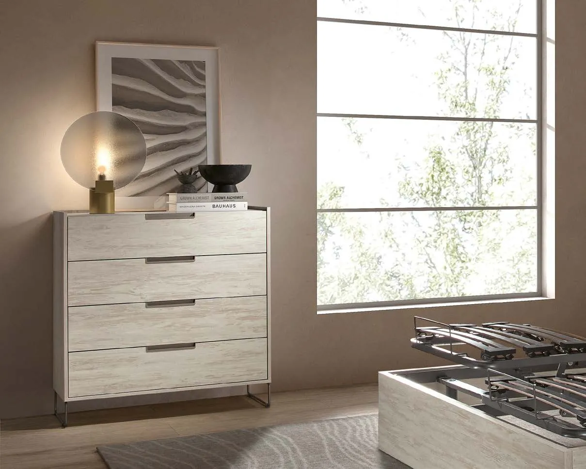 Commode quatre tiroirs en bois blanchi dans une chambre lumineuse
