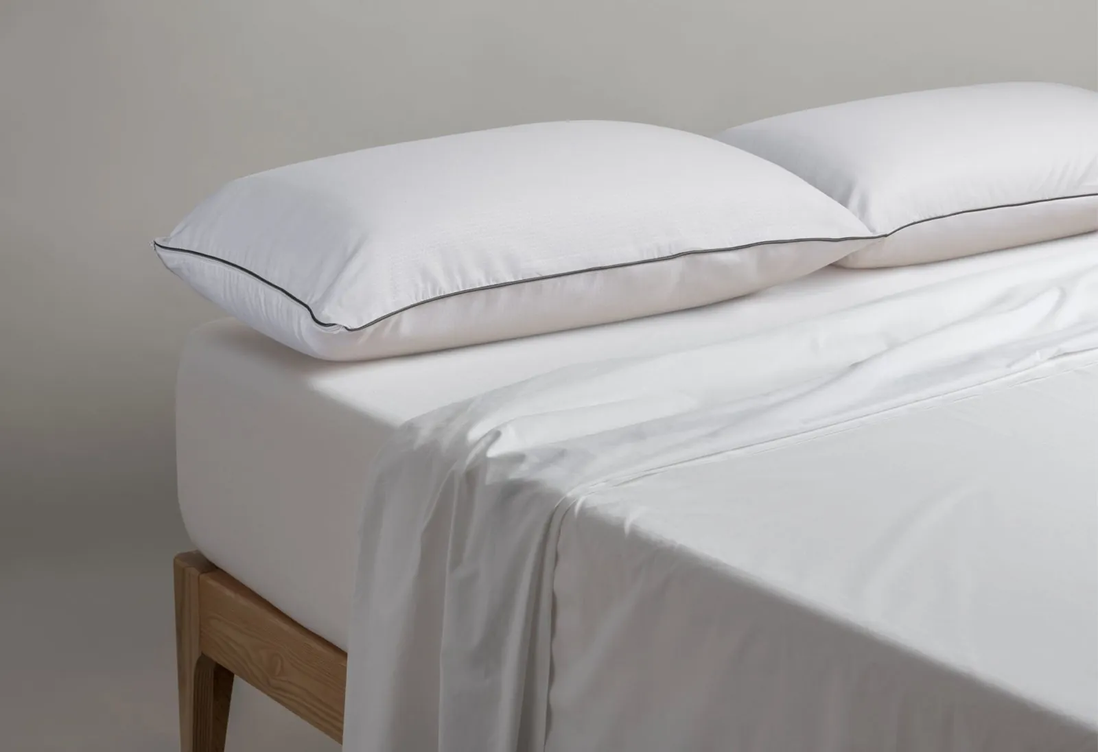 Oreillers blancs Velfont posés sur un lit en bois clair
